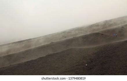 People walking through rough volcanic terrain in Ecuador on the side of Volcan Cotopaxi  - Powered by Shutterstock