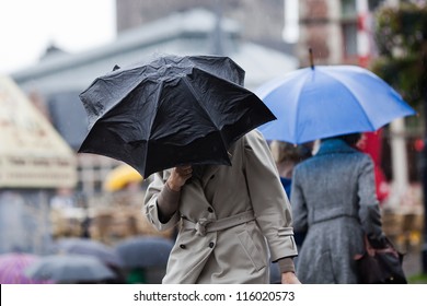 People Walking With Umbrellas In The Rainy City