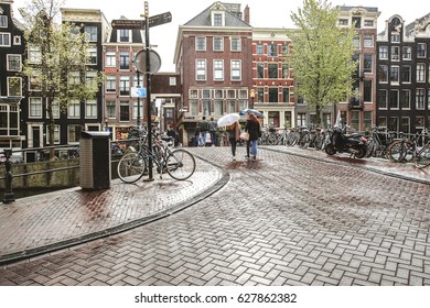 People walking under the rain on street in Amsterdam, Holland 