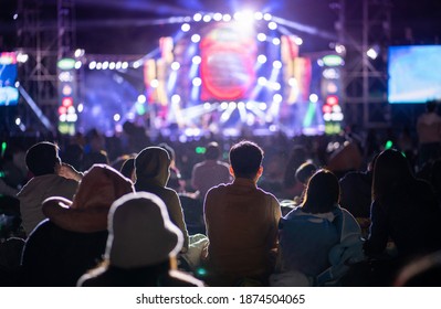 People Watching Concert In The Park At Open Air, Sitting In Front Of Stage,spectators At Background. 