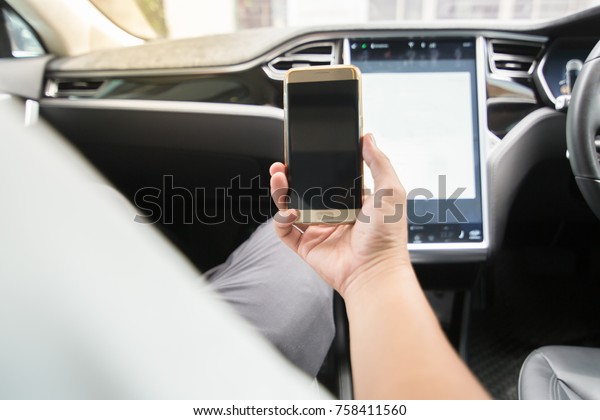 People are\
watching mobile phone on parked\
car.