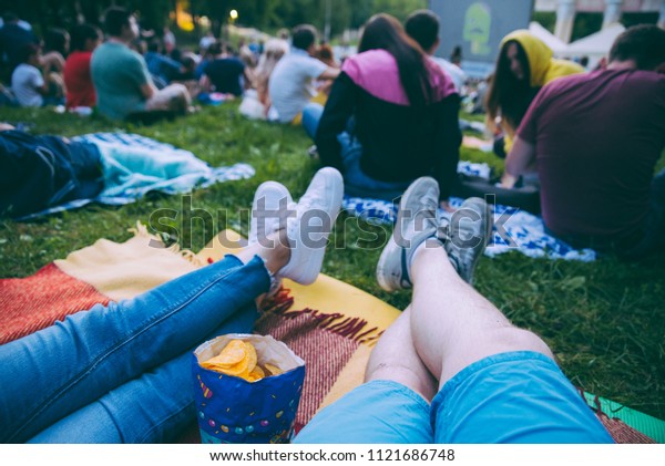 people\
watching movie in open air cinema in city\
park