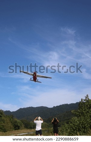 People watching a small airplane taking off from landing strip