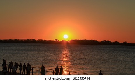 People Watching The Sunset On The Guaíba River In The City Of Porto Alegre.