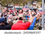 People waving USA flags in a large crowd at a rally. High quality photo