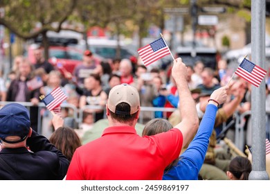 People waving USA flags in a large crowd at a rally. High quality photo - Powered by Shutterstock