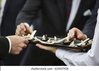 People Wearing Formal Clothes Eating Appetizers. Waiter Serving Food. Close Up Picture. Unrecognizable Men. 