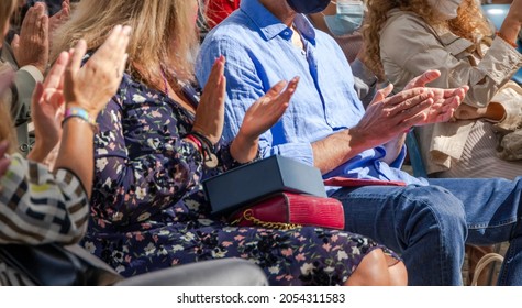 People Wearing Protective Face Masks And Clapping Their Hands At An Outdoor Event