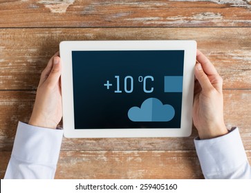 people, weather forecast and technology concept - close up of hands with metcast on tablet pc screen - Powered by Shutterstock