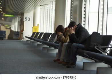 People who have missed their flight at the airport and have their head in their hands