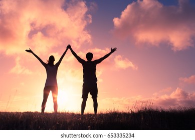 People winning concept. Man and woman with arms in the air celebrating victory. 