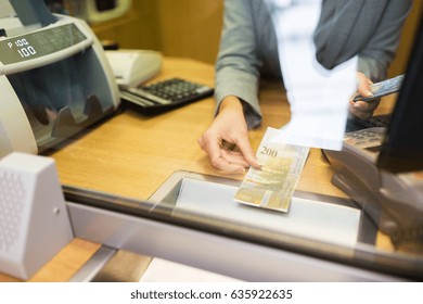 people, withdrawal, money, saving and finance concept - clerk counting swiss francs cash at bank office or currency exchanger - Shutterstock ID 635922635