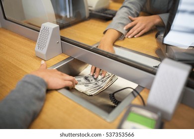 people, withdrawal, saving and finance concept - clerk giving cash money to customer at bank office or currency exchanger - Shutterstock ID 537353566