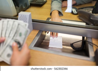 People, Withdrawal, Saving And Finance Concept - Clerk Giving Receipt To Customer With Money At Bank Office Or Currency Exchanger