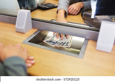 People, Withdrawal, Saving And Finance Concept - Clerk Giving Cash Money To Customer At Bank Office Or Currency Exchanger