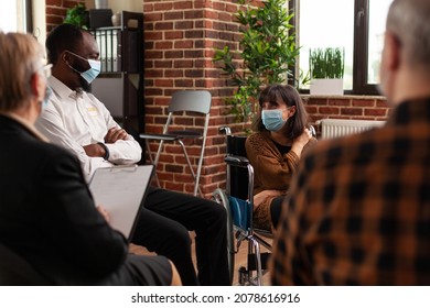 People And Woman Sitting In Wheelchair Having Conversation At Aa Meeting. Multi Ethnic Patients Attending Conversation With Psychiatrist At Support Group Therapy During Covid 19 Pandemic.