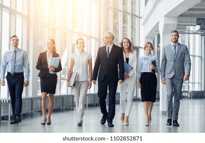 People, Work And Corporate Concept - Business Team With Folders Walking Along Office Building And Talking