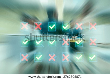 People work in an office while a digital display shows checkmarks and crosses representing completed and uncompleted tasks during a busy workday.