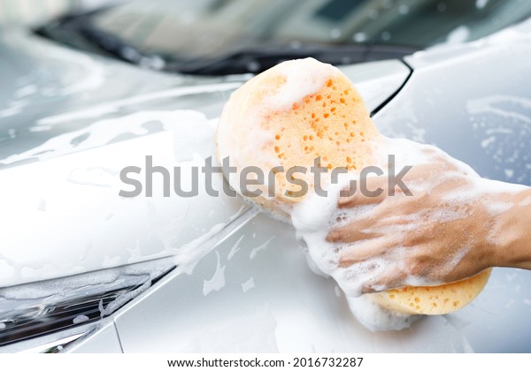 people worker man holding hand yellow
sponge and bubble foam cleanser window for washing car. Concept car
wash clean. Leave space for writing messages.
