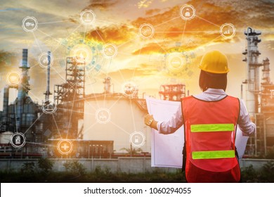 The People Worker Women Engineer Work Control At Power Plant Energy Industry Manufacturing Oil Refinery. Engineering Check Plant With Blue Print At Sunset Time.