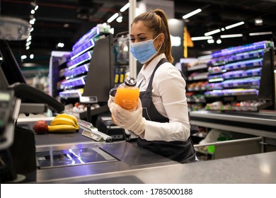 People Working During Global Virus Pandemic. Cashier At Supermarket Wearing Mask And Gloves Fully Protected Against Corona Virus.