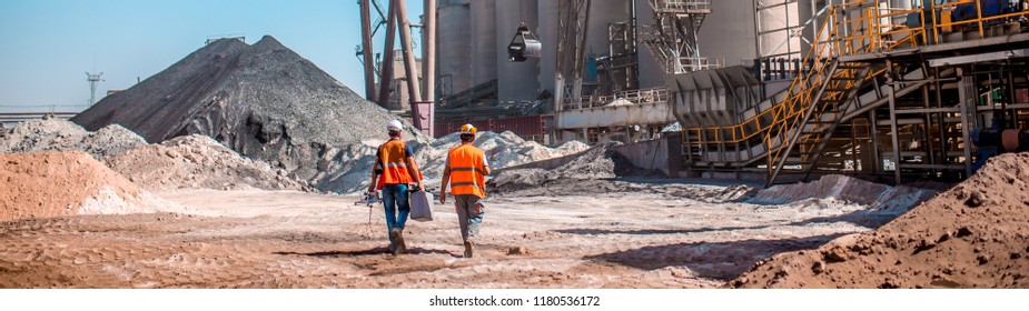 People are working in the industry. Modern technologies work at a cement plant. Technological work on the production of cement. Working atmosphere with copy space. Heaps of sand and soil raw materials - Powered by Shutterstock