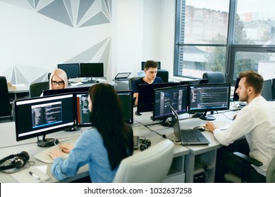 People Working In Modern Office. Group Of Young Programmers Sitting At Desks Working On Computers In It Office. Team At Work. High Quality Image - Powered by Shutterstock