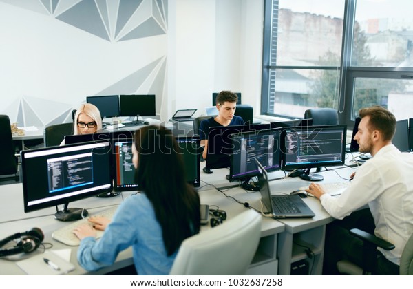 People Working In Modern Office. Group Of Young\
Programmers Sitting At Desks Working On Computers In It Office.\
Team At Work. High Quality\
Image