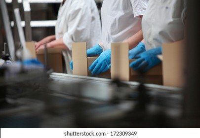 people working on packing line in factory