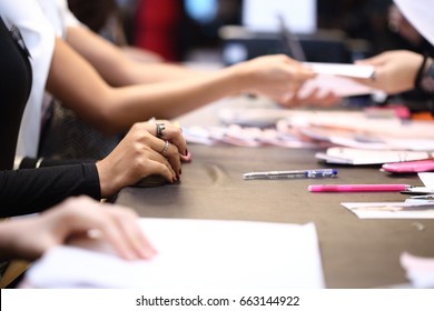 People Write Application Form And Submit Document For Job Interview, A Lot Of Paper On Table