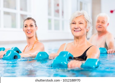 People young and senior in water gymnastics physiotherapy with dumbbells - Powered by Shutterstock