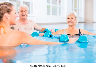 People young and senior in water gymnastics physiotherapy with dumbbells - Powered by Shutterstock