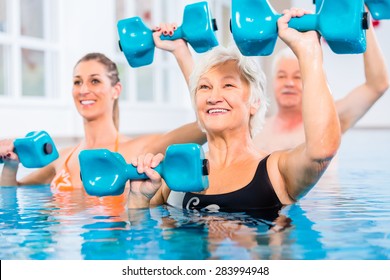 People young and senior in water gymnastics physiotherapy with dumbbells - Powered by Shutterstock