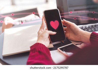 People youth culture dating online with application concept. Cloes up young woman hand using mobile phone with heart icon on device screen for meet up new love couple relationship. - Shutterstock ID 2175290787