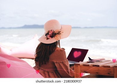 People Youth Culture Online Dating With Application Concept. Rear View Of Alone Asian Woman Relax At Beach Cafe On Summer Vacation. Using Laptop Looking For Love Via Internet.