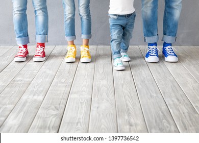 People's feet in colorful sneakers. Happy family - father, mother, son and daughter indoor. Parents and children at home