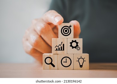 people's hand arranging wood block, pyramid shape, with business icon for strategy, action plan, growth business ,success process concept - Shutterstock ID 2130196142