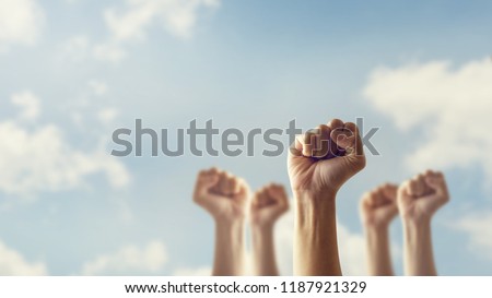 Peoples raised fist air fighting and sunlight effect, Competition, teamwork concept, background space for text.