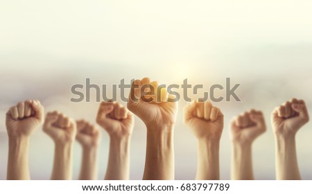 Peoples raised fist air fighting and sunlight effect, Competition, teamwork concept, background space for text.