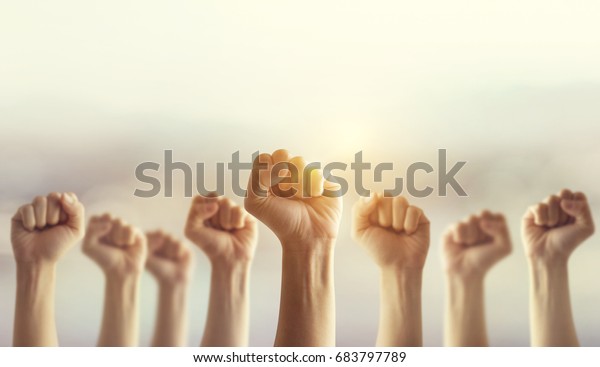 Peoples raised fist\
air fighting and sunlight effect, Competition, teamwork concept,\
background space for\
text.