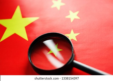 The People's Republic Of China A Flag Is Watched Through Magnifying Glass. Spies And Observation Of People's Republic Of China. Monitoring Of A Condition Of China. Concept Of Danger Of Theft Of Milita