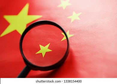 The People's Republic Of China A Flag Is Watched Through Magnifying Glass. Spies And Observation Of People's Republic Of China. Monitoring Of A Condition Of China. Concept Of Danger Of Theft Of Milita