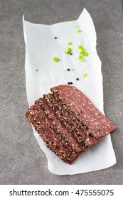 Pepper Crust Venison Bacon On A Piece Of Parchment Paper 