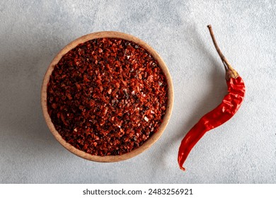 Pepper flakes.Red chili peppers in wooden bowl on light blue background.Dried chili peppers - Powered by Shutterstock