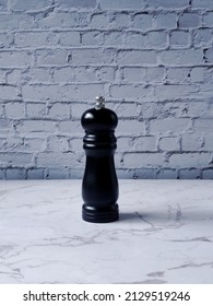 Pepper Grinder Isolated In Brick Wall Background