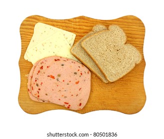 Pepper Jack Cheese And Pickle Pimento Luncheon Meat With Whole Wheat Bread On A Wood Cutting Board.