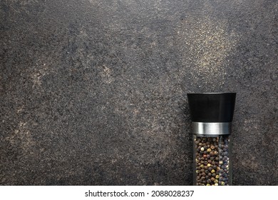 Pepper mill and ground pepper on black table. Top view. - Powered by Shutterstock