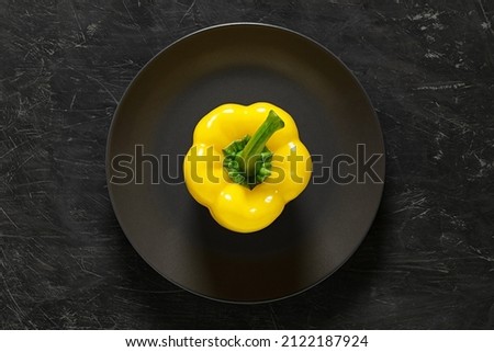 Pepper sweet yellow Bulgarian whole on gray plate, top view dark background, with space to copy text.