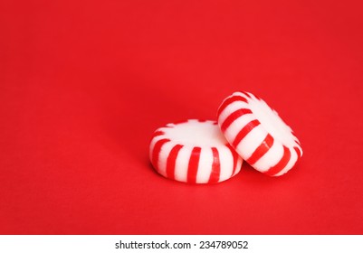 Peppermint Candy Over Red Christmas Background. Macro.