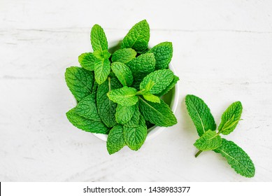 Peppermint leaves on white wooden  background. Bunch of Mint, Spearmint leaves. Top view. Copyspace